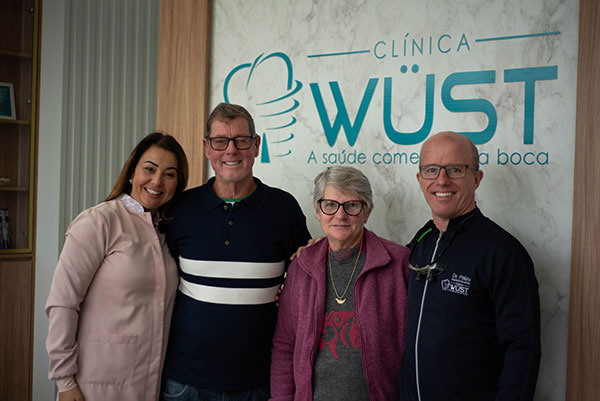 Família junto com Cássia e Dr. Pablo na Clínica Wüst em Rolante-RS, demonstrando o ambiente acolhedor e familiar da equipe.